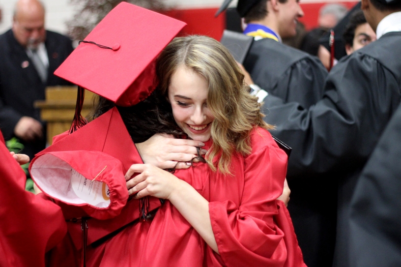 Nikos Frazier | The Vindicator Nicole Schmidt hugs her classmate after graduating from Canfield High School.