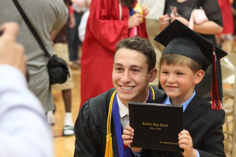 Nikos Frazier | The Vindicator Troy Williams(left) smiles next to his brother, McCoy Reid, 5, Williams graduated from Canfield High School.
