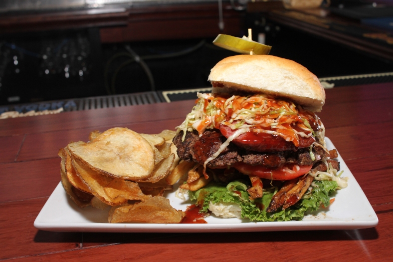Nikos Frazier | The Vindicator The Polish Boy All In Burger from Magic Tree Pub & Eatery in Boardman. Seated on a house made bun, a patty is topped with housemate slaw, polish smoked kielbasa, lettuce, tomato, french fries, and BBQ sauce.
